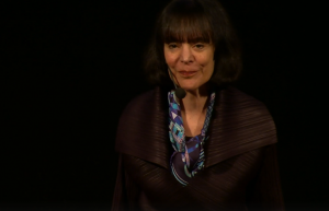 Woman in dark outfit presenting a talk on growth mindset.
